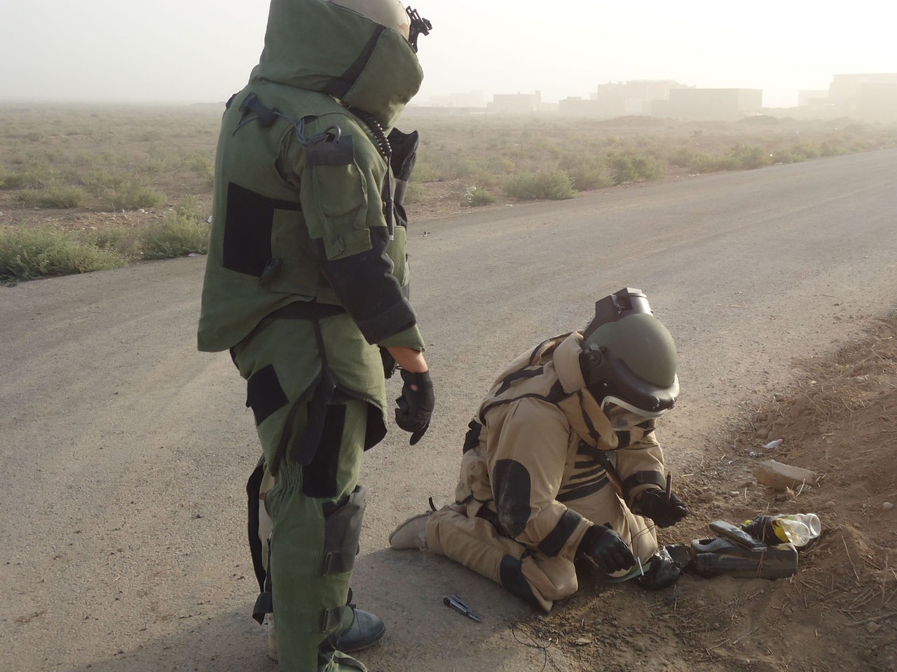 Two Iraqi EOD operators prepare to dispose of a partially disassembled IED. The device will be detonated on the spot by placing the block of plastic explosives C-4 on top of the main explosive charge and initiating it remotely. 
