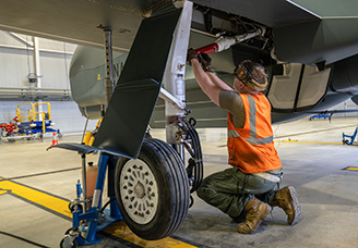 Un maintenancier de la NISRF inspecte la roue d’un drone RQ-4D « Phoenix ». 